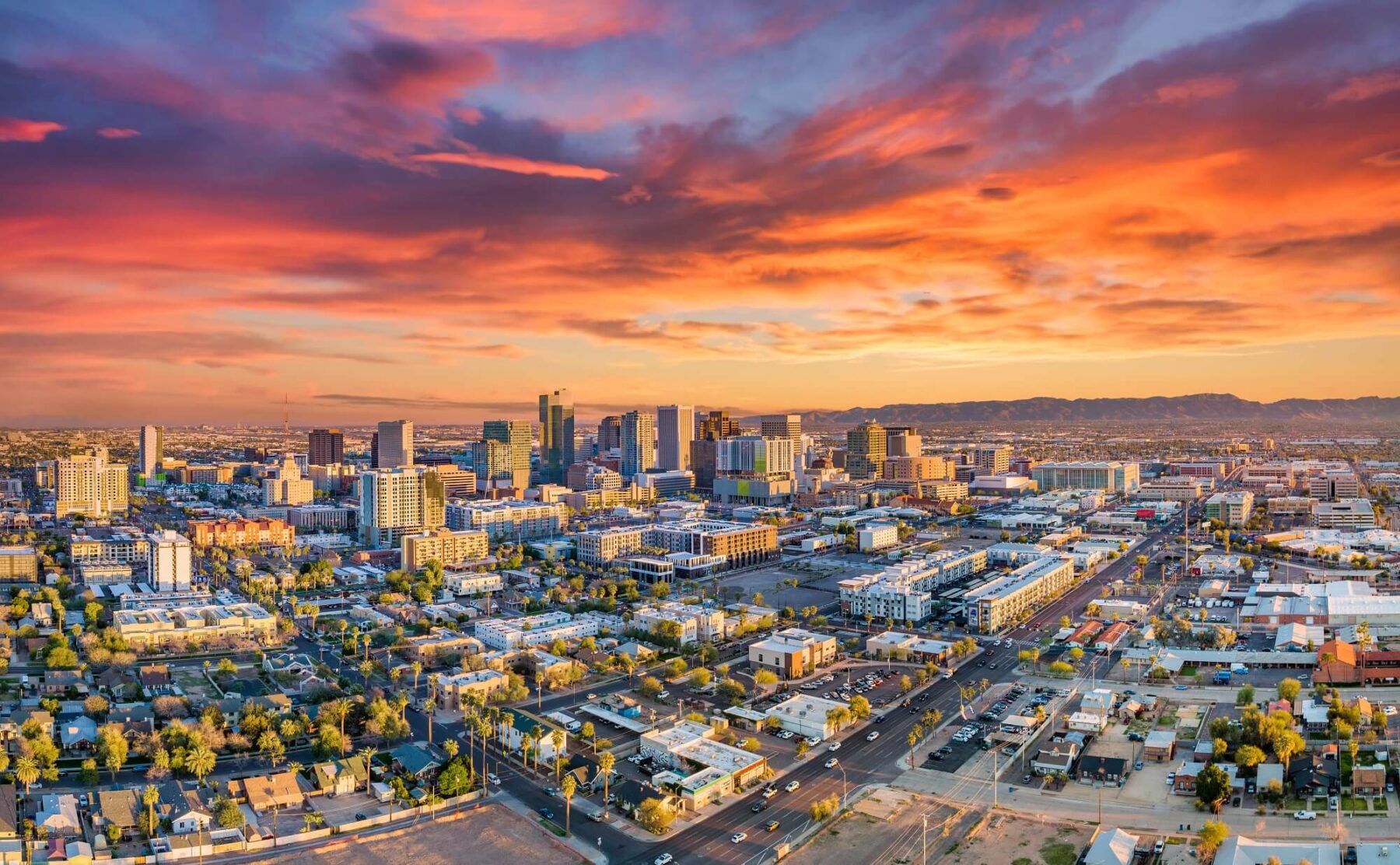 Aerial shot of downtown Phoenix skyline with sunset in distance